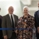 People gathered to cut the ribbon at newly renovated Deliverance House.